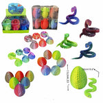 Rainbow neon toy snakes and eggs set, shown with a retail display box, multiple packs of eggs and snakes, several loose snakes, and a large close-up of a green textured egg with size annotations on a white background.