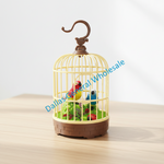 A miniature birdcage-shaped product with a cream-yellow cage body, brown top hook and base, and small colorful birds and green foliage inside, shown on a light wood surface against a white background. A diagonal 'Dallas General Wholesale' watermark overlays the center.