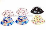 Six children's bucket hats arranged in two rows on a white background. The top row shows three hats: one pink with white unicorns and stars, one white with multicolor rainbows and unicorns, and one black with small colorful unicorns.