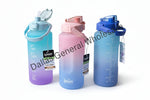 Gradient water bottles in blue, pink, and purple on a concrete floor with cardboard boxes in the background.
