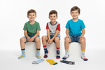Three children sitting on stools wearing colorful socks with a white background