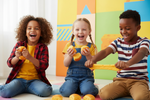 Three children playing with colorful blocks on a floor.