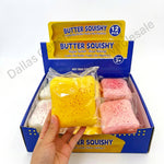 A hand holds a yellow 'Butter Squishy' squishy toy in front of its blue and yellow retail display box, which contains other colored squishies. The image has decorative doodle graphics and text overlays.
