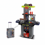 A toy workbench playset with a gray and black body, bright green top, and various colorful toy tools, shown alongside a matching gray rolling suitcase on a white background.