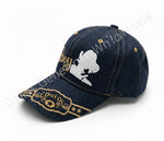 Denim cap with embroidered design on a concrete surface