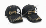 Two denim cowboy hats with embroidered designs on a concrete surface