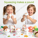 Two children smiling and squeezing white mushroom-shaped squishy toys, with more mushroom squishies and plushies displayed on a white surface with colorful confetti. Green text at the top reads 'Squeezing makes a sound'.