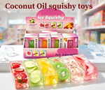 A display box and several rectangular translucent stress-relief toys filled with different fruit slices and pieces, shown on a white tabletop with a blurred store background. Large text at the top reads 'Coconut Oil squishy toys.