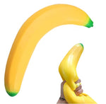 A yellow banana-shaped squishy toy with green tips, shown in two views on a white background: one large floating view and one smaller view of a hand squeezing it. Social media-style icons appear along the right side.
