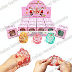 A boxed set of jelly cake squishies shown with three small pink retail boxes, three translucent gelatin cylinders in orange, pink, and blue, and two hands demonstrating the product by squeezing and stretching it. Large text reads '256', '144 PCS', and '7X6CM'.