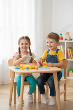 A young boy and girl sitting at a small wooden table, smiling and playing with colorful toy shapes in a bright children's room.
