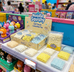 Noodle Squishy Soft Touch Collectible Toy display on a store shelf, showing packaged yellow, beige, and blue square squishy toys alongside a branded sign and other plush toys in the background.