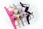 Assorted bras in various colors on a concrete surface