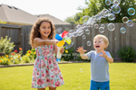 A young girl in a floral dress and a young boy in a light blue t-shirt and blue shorts are playing with bubbles in a sunny backyard. A large translucent watermark reading 'Dallas General Wholesale' is overlaid across the center of the image.