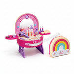 A children's toy makeup vanity set with a pink mirror stand, purple hair dryer, colorful toy bottles, beads, and accessories, shown next to a matching rainbow-shaped carrying case on a white background.