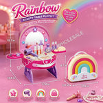 Rainbow Beauty Table Playset toy set shown with its packaging, dimensions, and included accessories on a pink sparkly background. The set includes a vanity table with mirror, accessories, a rainbow-shaped carrying case, and a small toy phone.