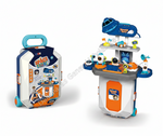 A children's space-themed toy set shown in two views: a rolling suitcase-style storage case on the left and the open play station on the right. The set includes a blue rocket, small vehicles, astronaut figures, and colorful station accessories.