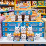 White cat-shaped squishy toys shown with their retail boxes, a hand squeezing one toy, dimensions, weight, and text noting that squeezing makes a sound. The image is collage-style on a white background.
