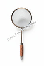 Metal strainer with wooden handle on a concrete surface