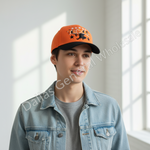 A young man wearing an orange and black baseball cap with 'TEXAS' and a star graphic, styled with a light blue denim jacket over a gray t-shirt in a brightly lit room.