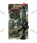 A 24-piece toy military action set in its original packaging, featuring a green and black camouflage toy rifle, pistol, goggles, and other accessories. The packaging is shown with dimension lines indicating 23.