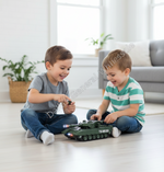 Two young boys sitting on a light wood floor in a bright living room, playing with a green toy tank car. One boy wears a gray t-shirt and jeans, and the other wears a green and white striped shirt with blue jeans.