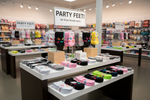 Store interior with 'Party Feet' novelty socks displayed on tables.